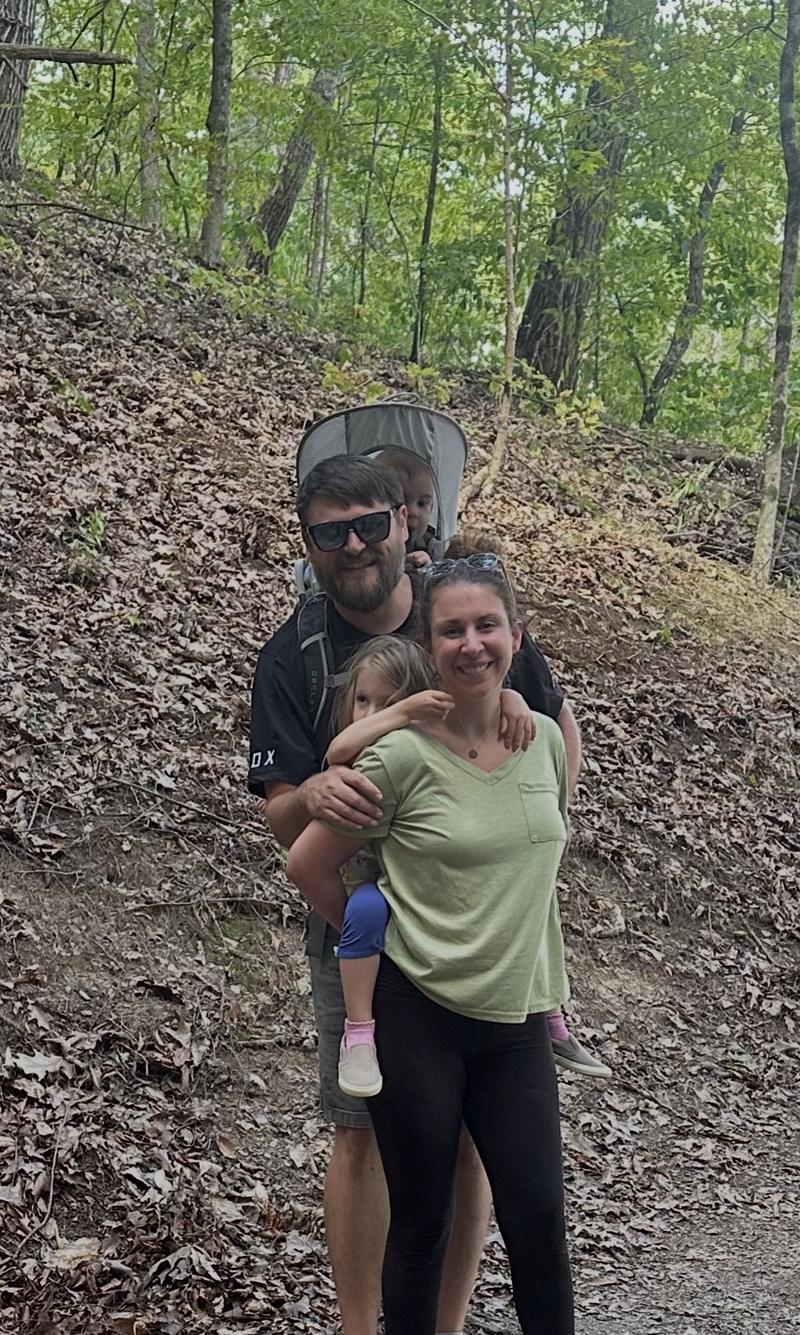 Tucker Watts with his wife and two children on a wooded family hike